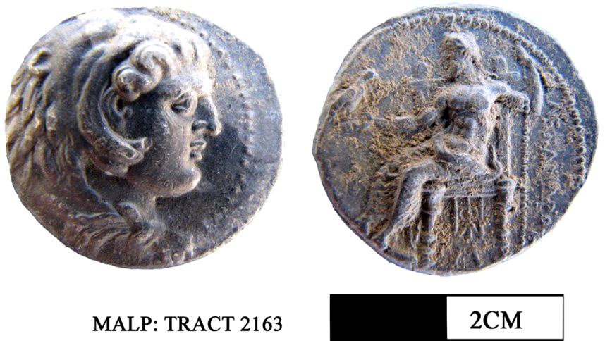 Εικ. 5: Τετράδραχμο που βρέθηκε κατά τη διάρκεια της έρευνας το οποίο απεικονίζει τον Ηρακλή/Μέγα Αλέξανδρο με λεοντοκεφαλή στην εμπρόσθια όψη και τη μορφή του ένθρονου Διός να φέρει αετό στο δεξί και σκήπτρο στο αριστερό του χέρι με την επιγραφή ΑΛΕΞΑΝΔΡΟ[Υ] στην οπίσθια όψη.